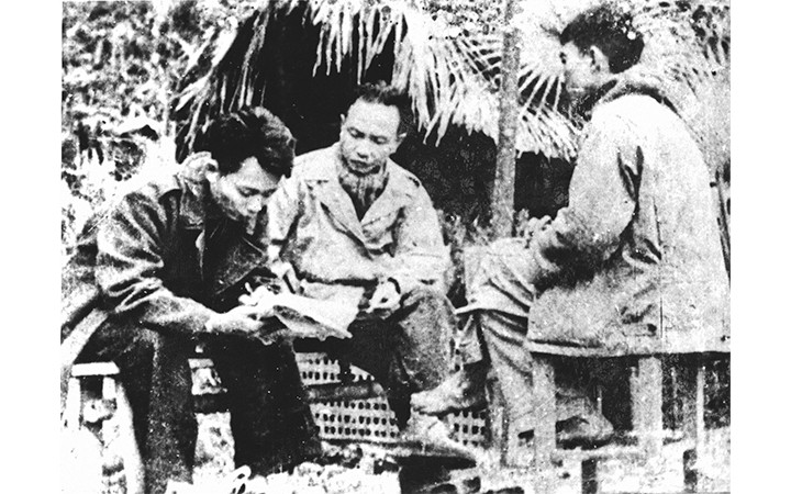 Comrades Truong Chinh, Thep Moi and Ha Xuan Truong review the first draft issue of Nhan Dan Newspaper in 1951. (Document photo)