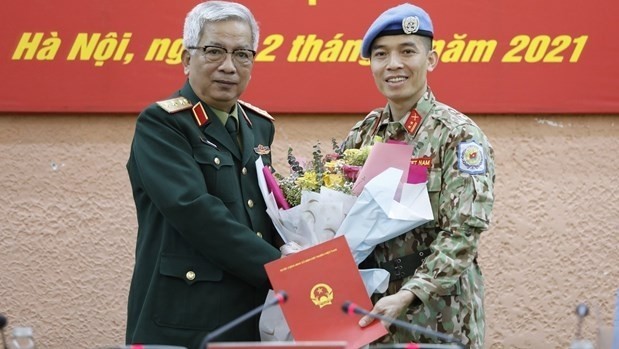 Deputy Defence Minister Sen. Lieut. Gen Nguyen Chi Vinh (L) presents decision to Lieut. Col Tran Duc Huong (Photo: VNA) 