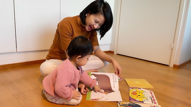 Quynh Hanh and her daughter share the joy of reading a Vietnamese picture book.