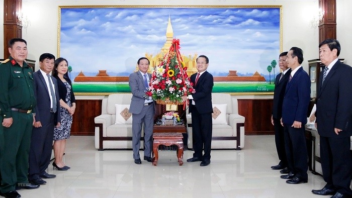 Vietnamese Ambassador to Laos Nguyen Ba Hung (L) congratulates the Lao People’s Revolutionary Party Central Committee on the occasion of the 66th founding anniversary of the Lao Party. (Photo: VNA)