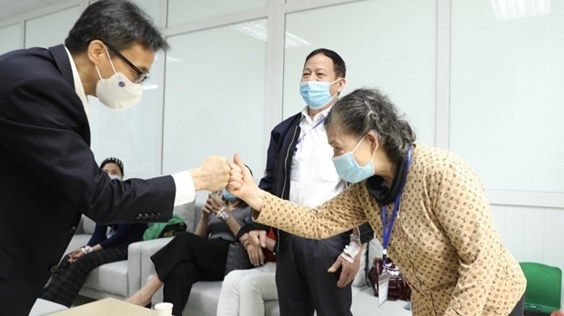 Deputy Prime Minister Vu Duc Dam visits volunteers participating in the second trial phase of Nano Covax. (Photo: VNA)