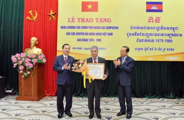 Cambodian Ambassador to Vietnam Chay Navuth (R) and Permanent Deputy Governor of SBV Dao Minh Tu (L) award the Royal Order of Sahametrei to specialists of Team K. (Photo: SBV)