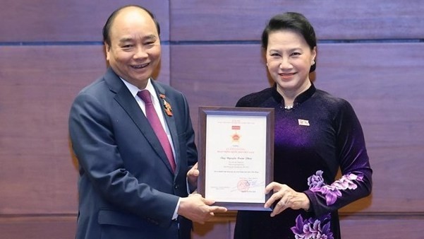 NA Chairwoman Nguyen Thi Kim Ngan presents the insignia for NA operations to Politburo member and Prime Minister Nguyen Xuan Phuc, who is deputy to the 11th, 13th, 14th National Assemblies (Photo: VNA)