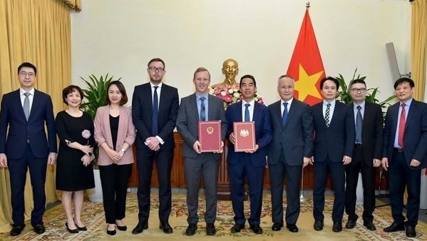 Representatives of Vietnam and the UK hand over notes confirming the date when the UKVFTA comes into force. (Photo: VNA)