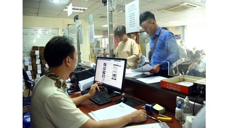 The Hanoi Business Registration Office's staff solve legal procedures for businesses. (Photo: VNA)