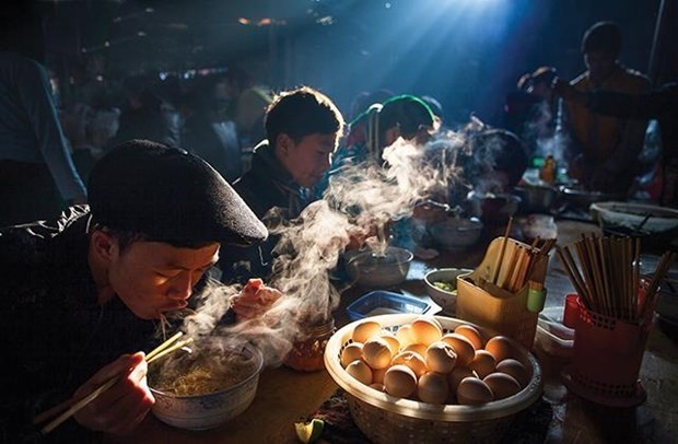 The work "Breakfast at a weekly market gathering" by Nguyen Huu Thong wins the Silver Medal in the Travel category at the 10th International Artistic Photo Contest in Vietnam. (Photo: VNA)