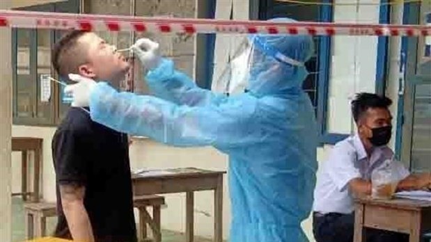 A medical worker takes sample from a man undergoing quarantine in An Giang province for COVID-19 testing (Photo: VNA) 
