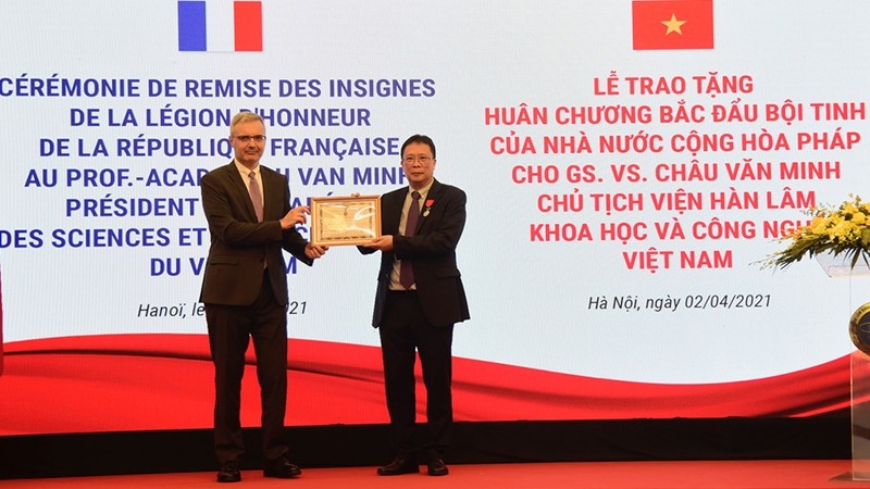French Ambassador to Vietnam Nicolas Warnery (left) presents the Order of the Legion of Honour to Professor Chau Van Minh. 