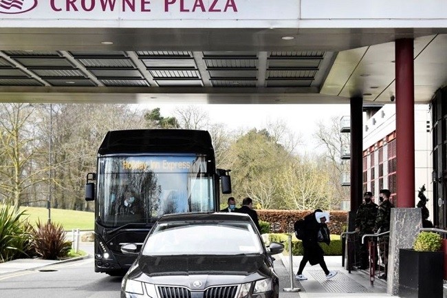 A passenger covers her face after getting off a designated quarantine bus at Crowne Plaza Dublin Airport Hotel, as Ireland introduces hotel quarantine programme for 'high-risk' countries' travellers, in Dublin, Ireland March 26, 2021. (File photo: Reuters)