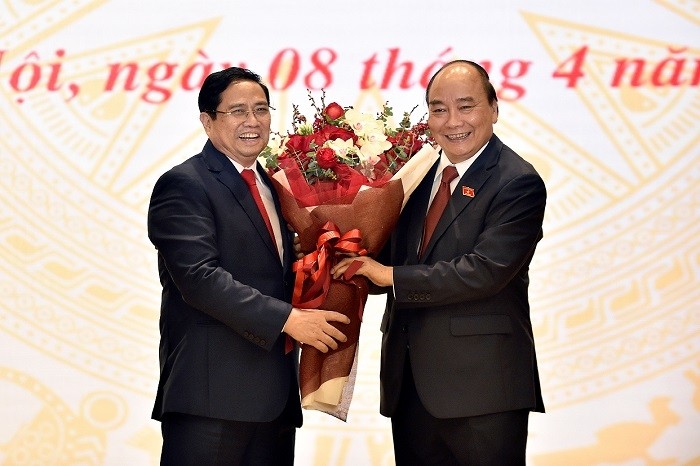 Prime Minister Pham Minh Chinh (L) presents flowers to State President Nguyen Xuan Phuc at the duty handover ceremony on April 8. (Photo: VGP)