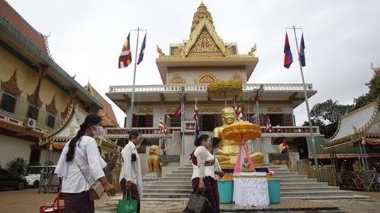 Cambodians wear face masks at a pagoda.