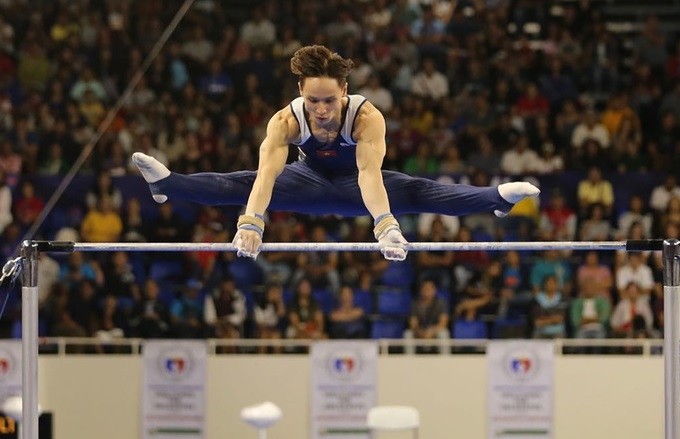 Dinh Phuong Thanh performs on horizontal bar at the 30th SEA Games in the Philippines.