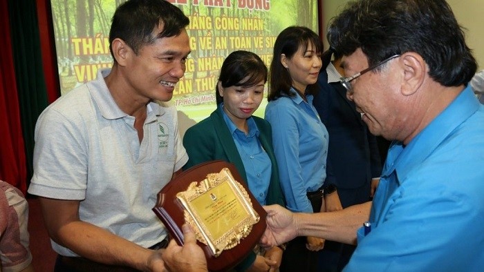 Phan Manh Hung, President of Vietnam Rubber Trade Union (far right) presents the title of outstanding rubber workers to labourers under the rubber industry. (Photo: congdoancaosu.vn)