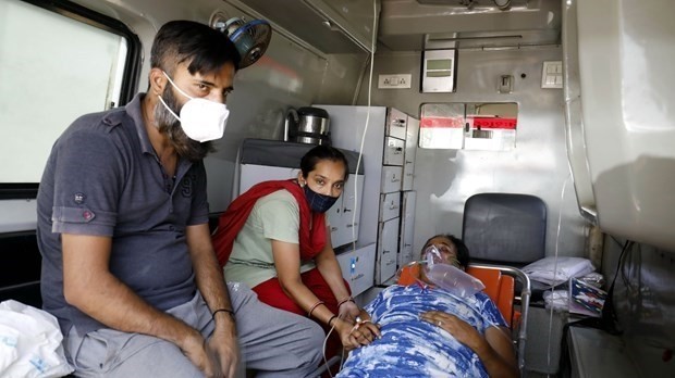 A COVID-19 patient being treated in an ambulance to wait for a bed in hospital (Photo: xinhua/VNA)