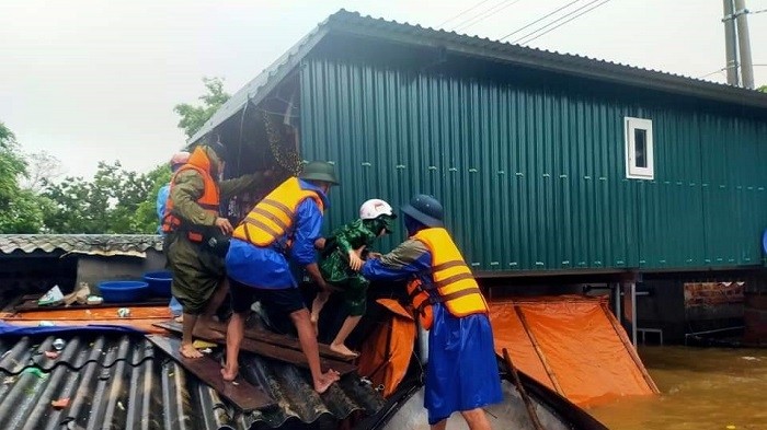 Police of Cam Thuy Commune, Le Thuy District, Quang Binh Province, evacuate a local from a deeply inundated house during the severe flooding in October 2020. (Photo: NDO/Huong Giang).