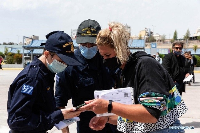 Members of Greek Coast Guard check a passenger's travel documents in Piraeus, Greece, on April 27, 2021. In a televised address to the nation last week, Greek Prime Minister Kyriakos Mitsotakis said that Greeks will not be allowed to travel freely during the Christian Orthodox Easter, which will be celebrated on May 2, due to the still severe epidemic situation. (Photo: Xinhua) 