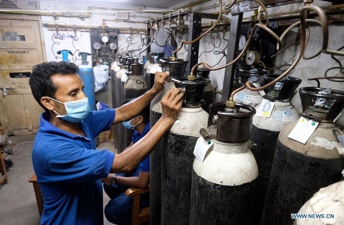 A hospital worker adjusts the oxygen cylinders to supply oxygen through the central pipeline for the patients at a private hospital in Kolkata, India, April 28, 2021. (Source: Xinhua)
