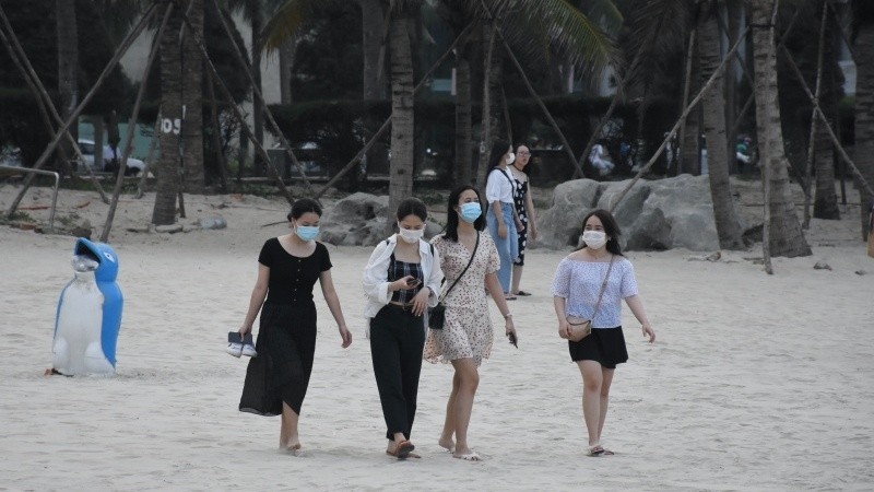 Tourists wear masks at a beach in Da Nang.