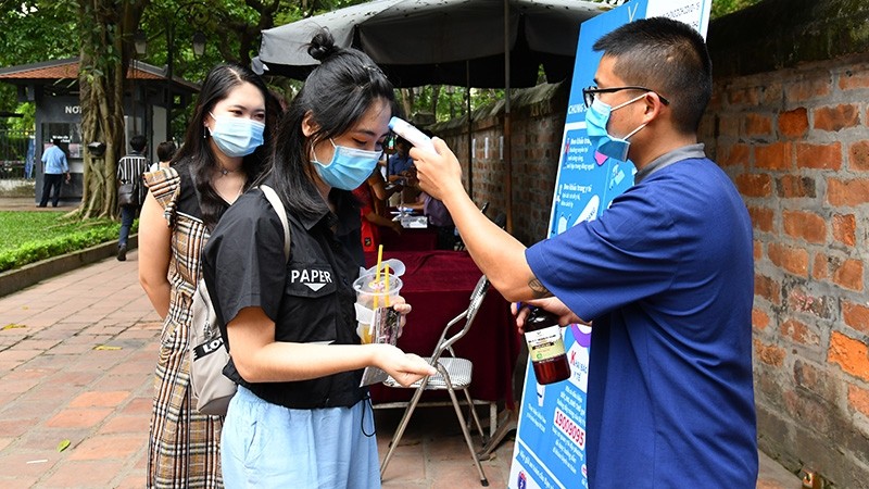 A staff at the Van Mieu - Quoc Tu Giam relic takes measures to prevent apnd control COVID-19 for visitors.