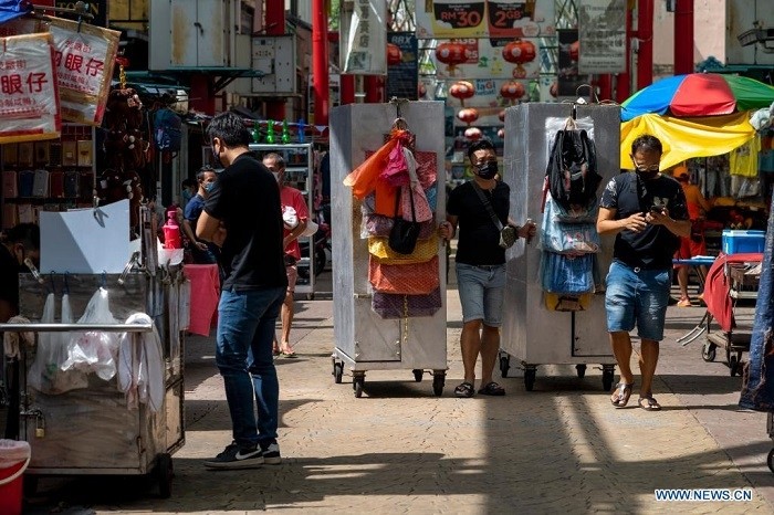 People wearing face masks walk on a street in Kuala Lumpur, Malaysia, April 28, 2021. (Photo: Xinhua)