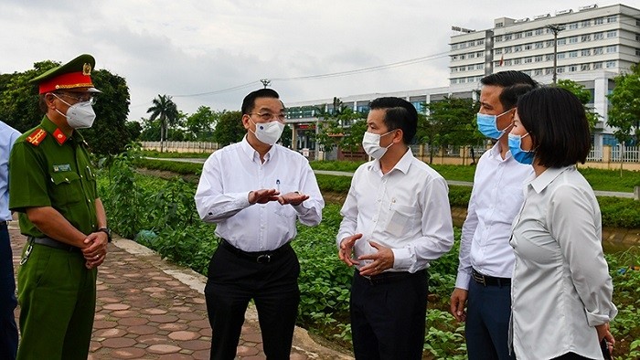 Chairman of the People's Committee of Hanoi Chu Ngoc Anh (second from left) inspects medical blockade and isolation at the National Hospital for Tropical Diseases base 2 in Kim Chung, Dong Anh District, May 5, 2021. (Photo: NDO/Duy Linh)