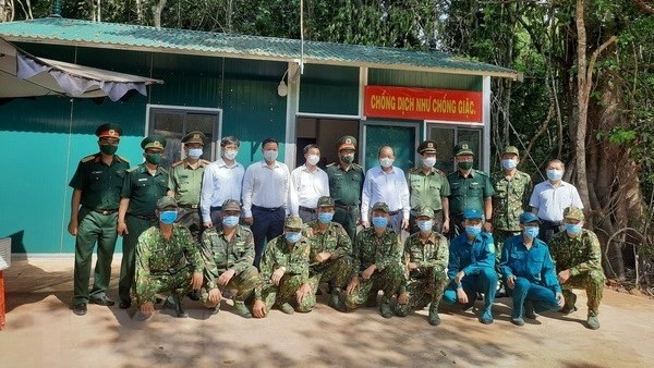 Deputy Prime Minister Truong Hoa Binh (standing, eighth from left) and local officials visit soldiers at a COVID-19 prevention post in the Chang Riec border forest area, Tan Bien District, Tay Ninh Province, May 9, 2021. (Photo: VNA)
