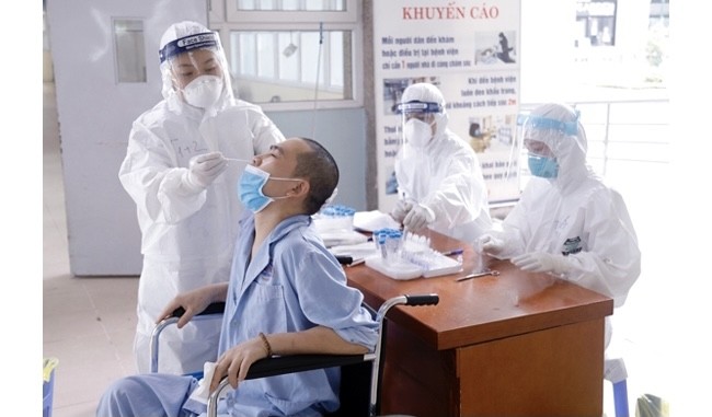 A patient at Vietnam's National Cancer Hospital, also known as K Hospital, has a sample taken for COVID-19 testing. 