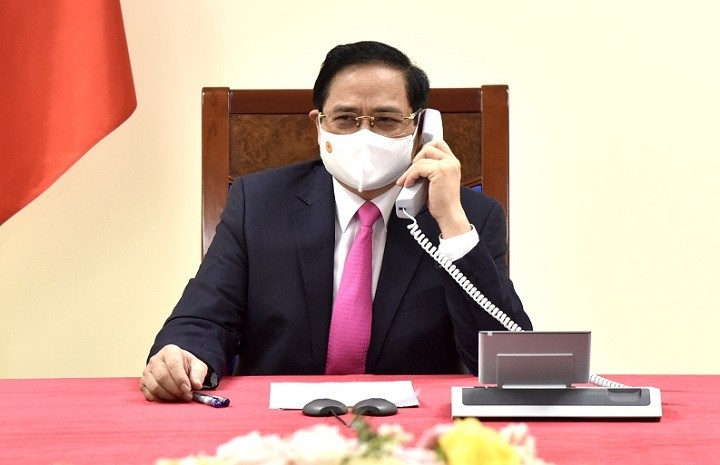 Prime Minister Pham Minh Chinh talks on the phone with his Japanese counterpart Suga Yoshihide. (Photo: NDO/Tran Hai)