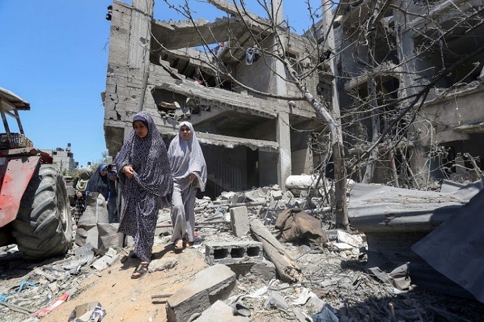 Palestinian women walk at the site of destroyed houses in the aftermath of Israeli air and artillery strikes in the northern Gaza Strip on May 14 2021. (Photo: Reuters)