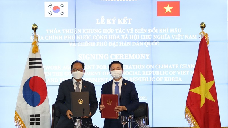 Minister of Natural Resources and Environment Tran Hong Ha (R) and Ambassador of the ROK to Vietnam Park Noh-wan sign the Cooperative Framework Agreement on Climate Change.