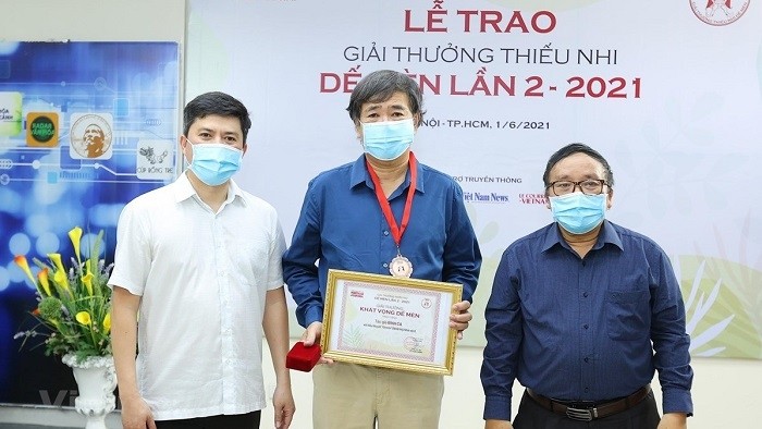 Writer Binh Ca (middle) receives the ‘Cricket Desire’ for his novel ‘Di Tron’ (Seeking shelter). (Photo: VNA)