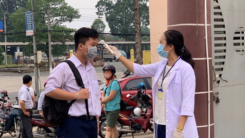 A student has his temperature checked at Nguyen Thi Minh Khai High School in Thu Dau Mot city, Binh Duong province.