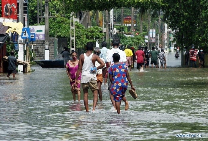 People wade through a flooded road in Gampaha, about 20 km from Colombo, Sri Lanka, on June 4, 2021. Sri Lanka's Meteorological Department on Thursday said that heavy rains and strong winds were expected in several areas of the island country in the coming days due to the onset of the southwest monsoons. (Photo: Xinhua)