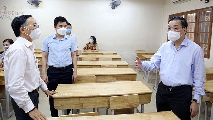 Chairman of the Hanoi municipal People's Committee Chu Ngoc Anh (R) inspects the COVID-19 prevention and control preparations for the 10th grade entrance exams at Kim Lien High School, Dong Da District, June 7, 20201. (Photo: NDO/Nguyen Trang)