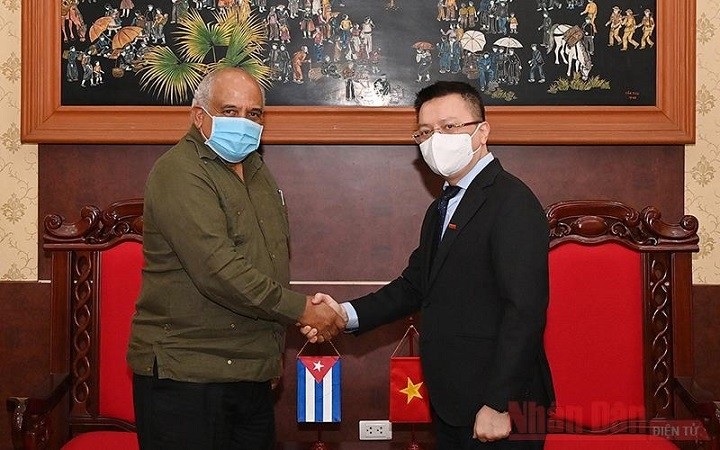 Editor-in-chief of Nhan Dan Newspaper Le Quoc Minh (R) greets Cuban Ambassador to Vietnam Orlando Nicolas Hernandez Guillen. (Photo: NDO)