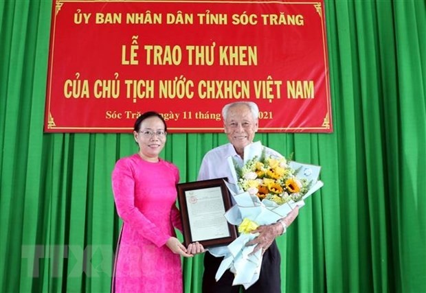 Vice Chairwoman of the Soc Trang provincial People's Committee Huynh Thi Diem Ngoc hands over the President's letter to 98-year-old Tran Cang on June 11. (Photo: VNA)