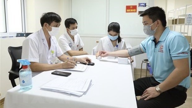 A volunteer takes a screen test before receiving Nano Covax COVID-19 vaccine shot in the third phase of the human trials. (Photo: VNA)