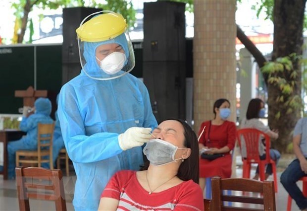 A medical worker take a nasal-throat swab for COVID-19 testing. (Photo: VNA)