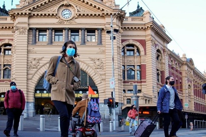Pedestrians cross the road at Flinders Street Station on the first day of eased coronavirus disease (COVID-19) restrictions for the state of Victoria following an extended lockdown in Melbourne, Australia, June 11, 2021.(File photo: Reuters)
