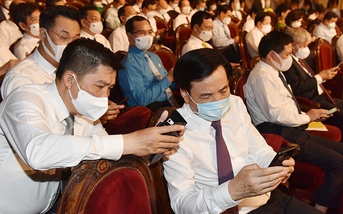 Delegates send SMS messages to the National Humanitarian Portal 1400 to donate to the COVID-19 Vaccine Fund. (Photo: Duc Khanh)